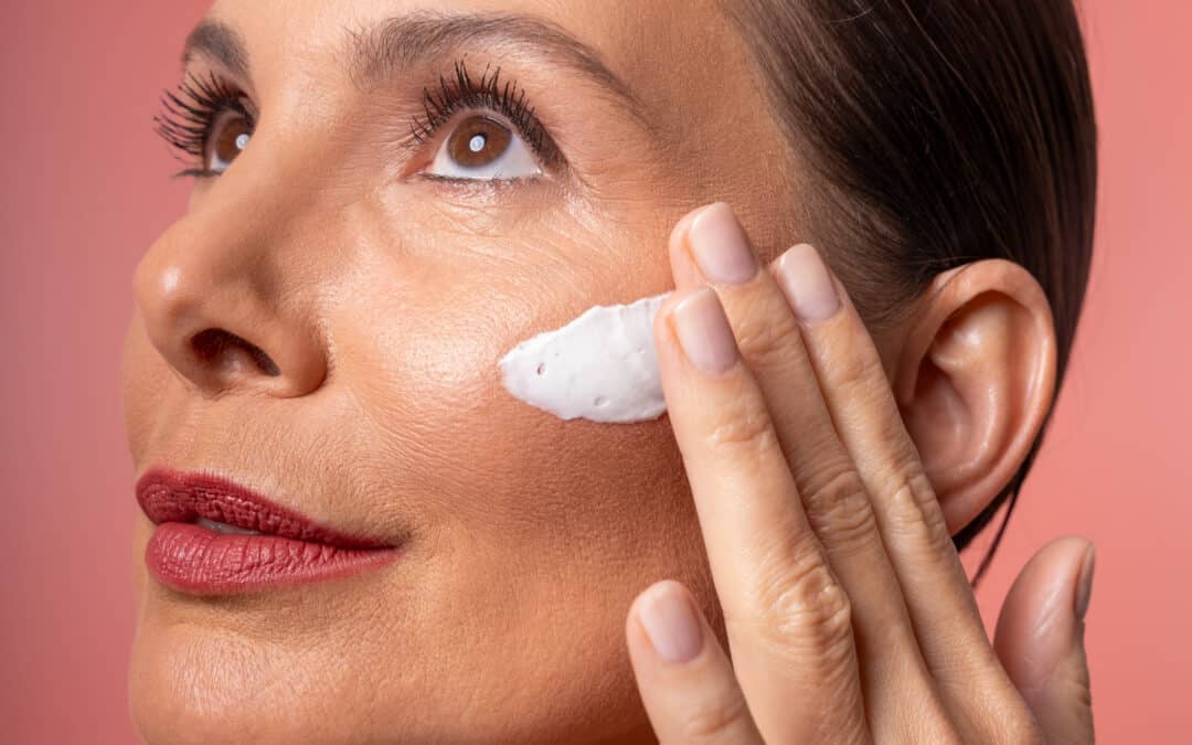 Frau trägt Creme auf die Wange auf, als Skin Longevity Anwendung für eine glatte und gepflegte Haut